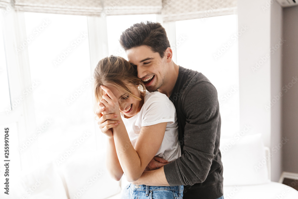 Portrait of excited couple laughing and hugging together while having fun at home Portrait of excited couple laughing and hugging together while having fun at home