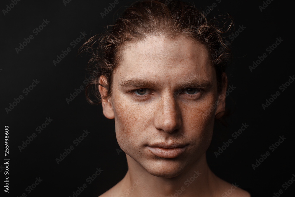 Portrait of a handsome long-haired man with drawn hair and freckles Portrait of a handsome long-haired man with drawn hair and freckles