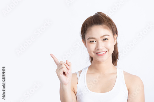 Beautiful Attractive Asian young women smile and pointing to copy space for display product feeling happiness and fun Isolated on white background Beauty Concept
