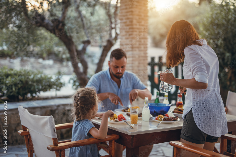 Father and dauther having mediterranean dinner on a terrace during summer vacation