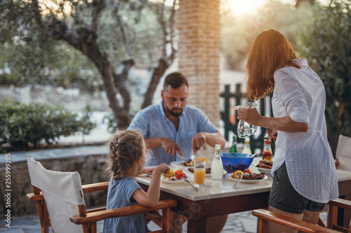 Father and dauther having mediterranean dinner on a terrace during summer vacation