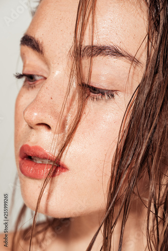 portrait of beautiful girl with coral lips and wet hair isolated on grey