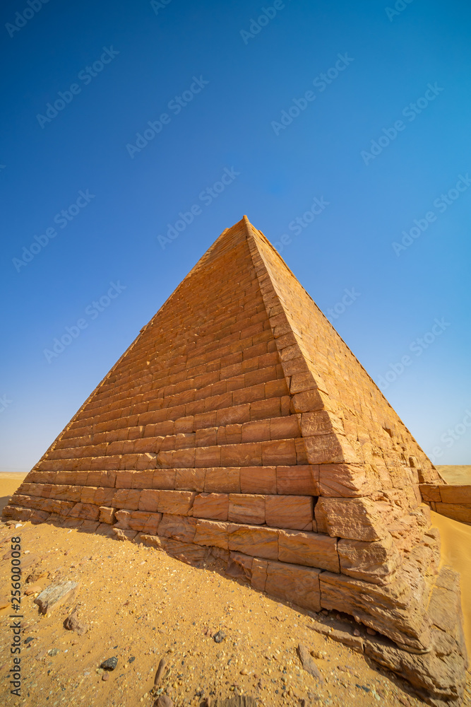Restored pyramid in Meroe in the desert of Sudan shining in bright sunlight Restored pyramid in Meroe in the desert of Sudan shining in bright sunlight