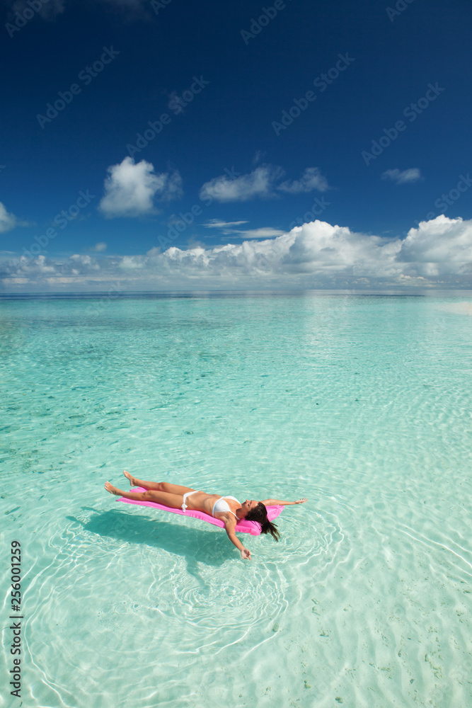 Woman swim and relax in the sea. Happy island lifestyle. White sand, crystal-blue sea of tropical beach. Vacation at Paradise. Ocean beach relax, travel to Maldives islands