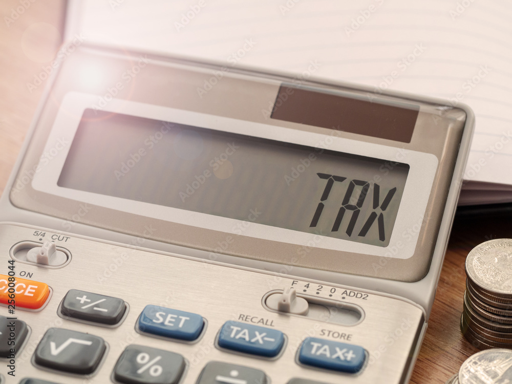Tax word on calculator. Business and finance tax concept for yearly tax time. Tax word on calculator. Business and finance tax concept for yearly tax time.