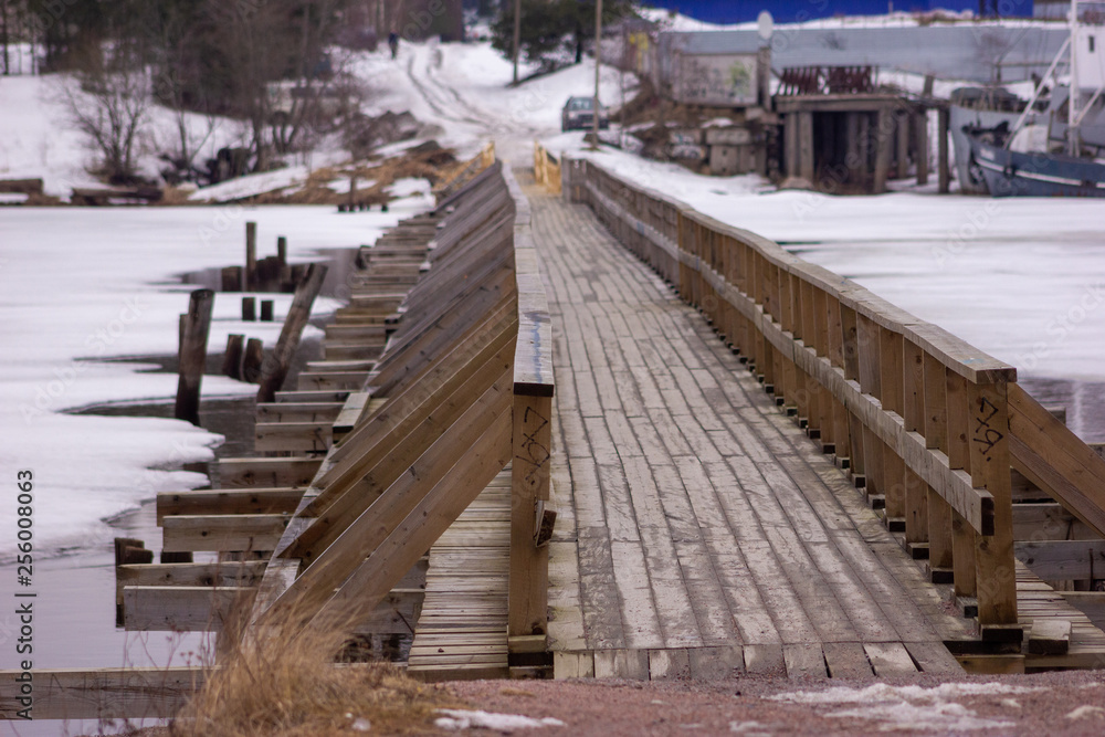 Wooden bridge at Vuoksa river estuary фе Priozersk, Priozersky District, Leningrad Oblast, Russia. March 2019.