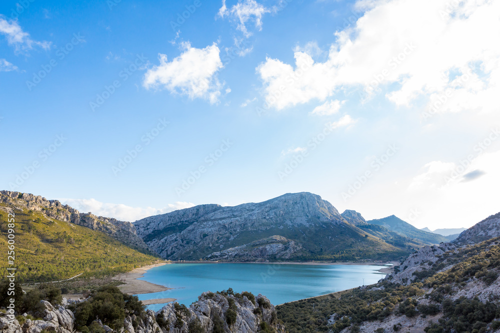 Ein blauer Stausee am Torrent de Gorg auf Mallorca wird von Bergen umschlossen