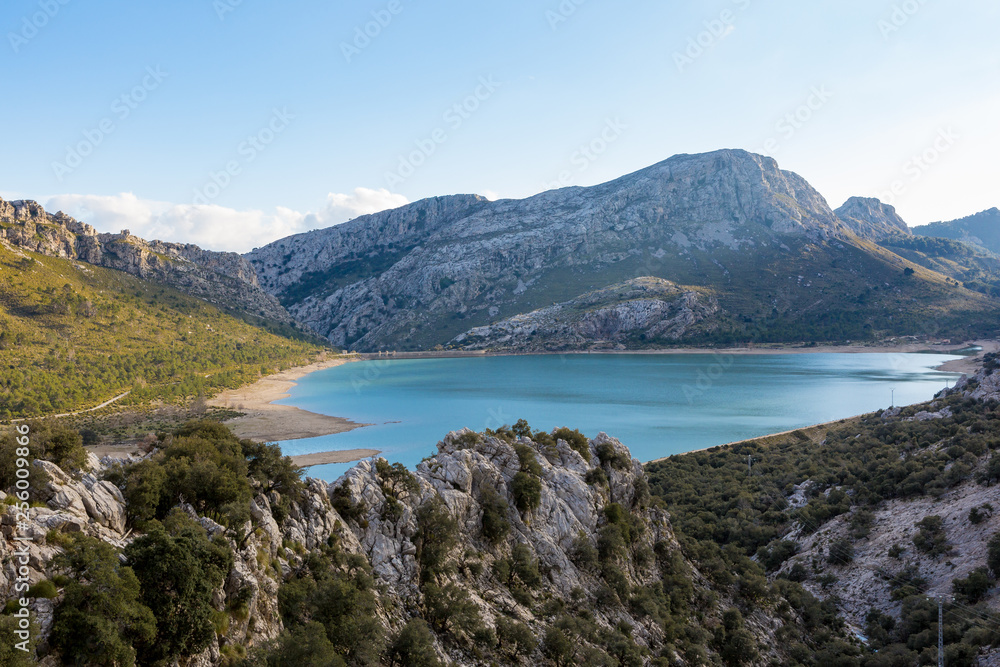 Ein blauer Stausee am Torrent de Gorg auf Mallorca wird von Bergen umschlossen
