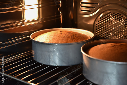 Close up of baking chocolate cakes in the hot oven, homemade cake.