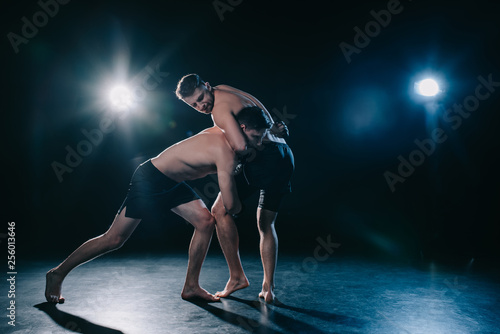 Foto mma fighter doing chokehold and joint lock to another sportsman in stance during