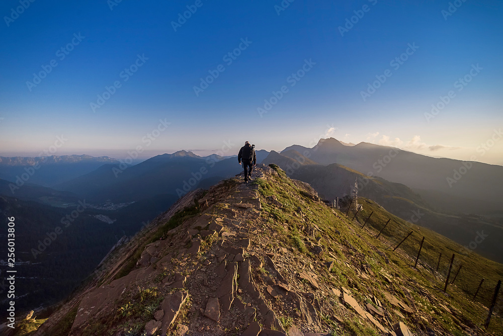 man walks on the crest of the mountain on a sunny day