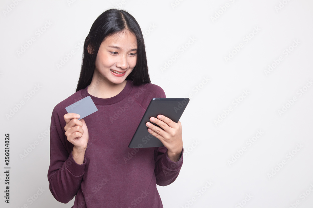 Young Asian woman is shopping online with credit card and tablet. Young Asian woman is shopping online with credit card and tablet.