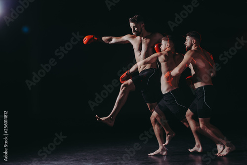 multiple exposure of strong shirtless muscular mma fighter in boxing gloves doing punch in jump