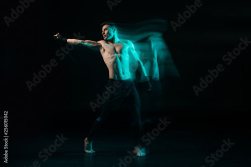 long exposure of green light and sporty muscular mma fighter doing punch and looking away © LIGHTFIELD STUDIOS