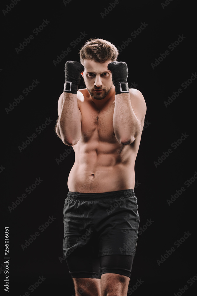 muscular strong shirtless mma fighter in stance isolated on black