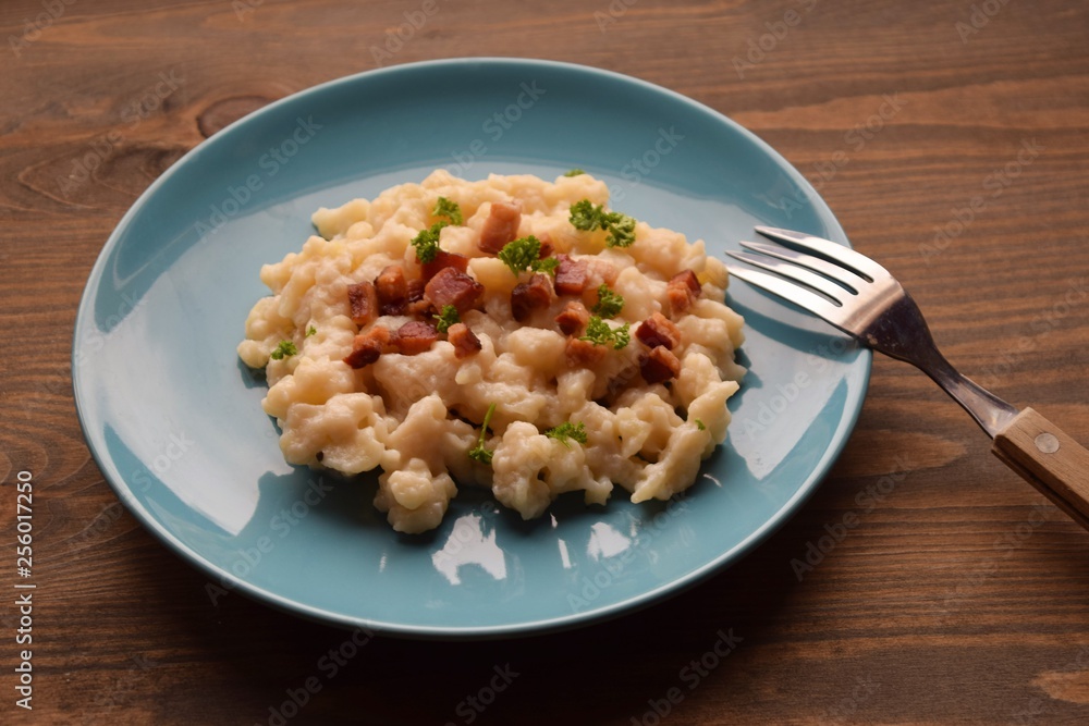 Slovak traditional potato gnocchi with sheep cheese and bacon,wooden table Slovak traditional potato gnocchi with sheep cheese and bacon,wooden table
