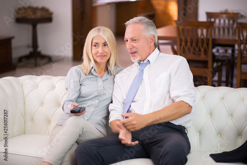 Portrait of a mature couple watching a tv show at home © Minerva Studio