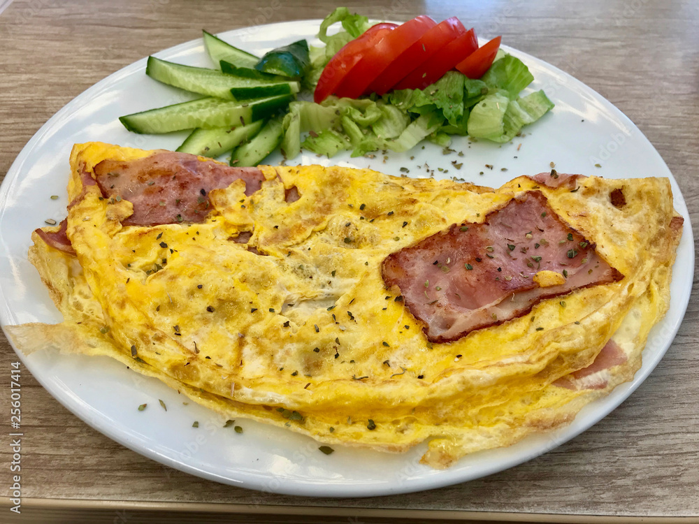 Omelette with Bacon served with Cucumber and Tomatoes. Omelette with Bacon served with Cucumber and Tomatoes.