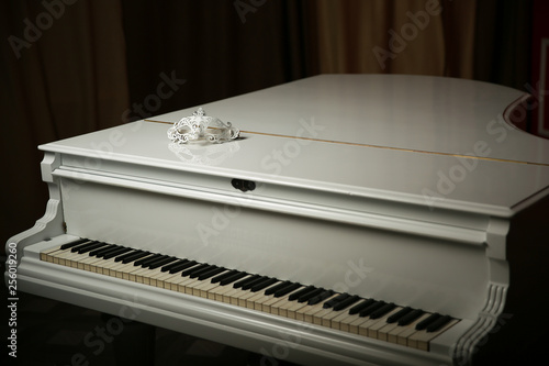 vintage mask is on a white piano. white grand piano with opened  keyboard.  the keyboard of the piano. ancient grandpiano on a dark background photo