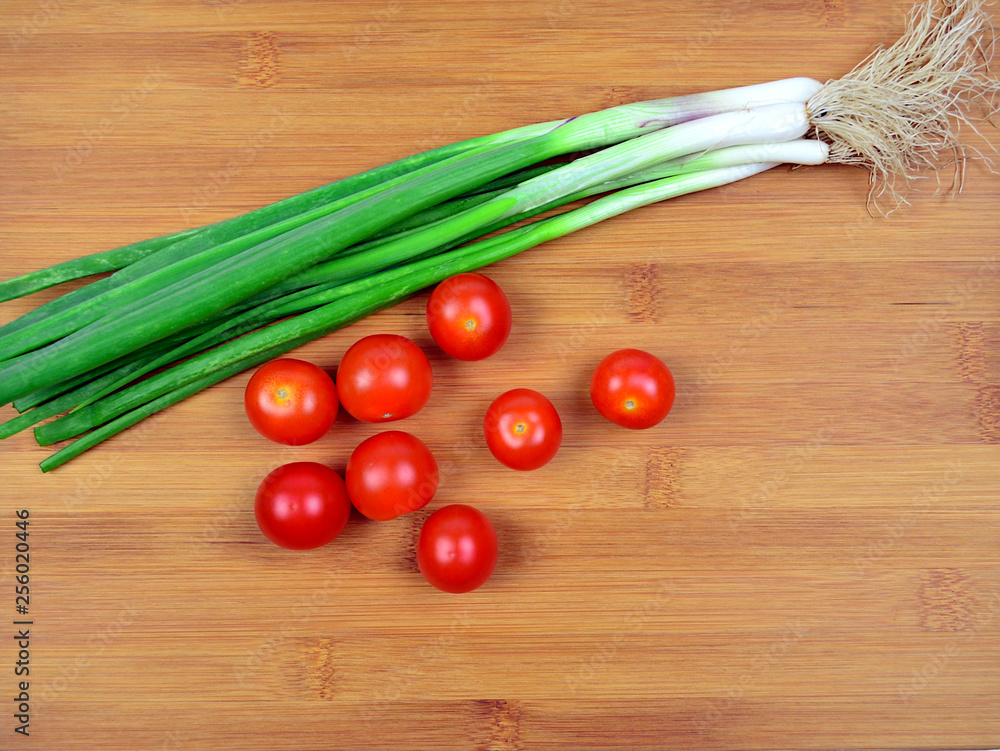 Fresh Red Cherry tomatoes and Green Spring Onion on wooden background Fresh Red Cherry tomatoes and Green Spring Onion on wooden background