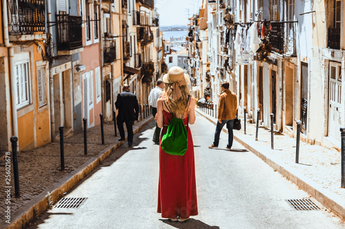 Young traveling woman walking on the streets of Lisbon city and looking at beautiful view © seligaa
