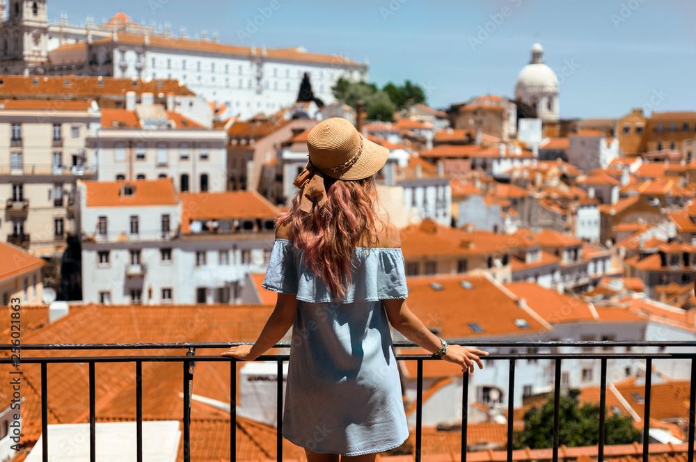 Fotografie Young traveling woman walking on the streets of Lisbon city and looking at beaut