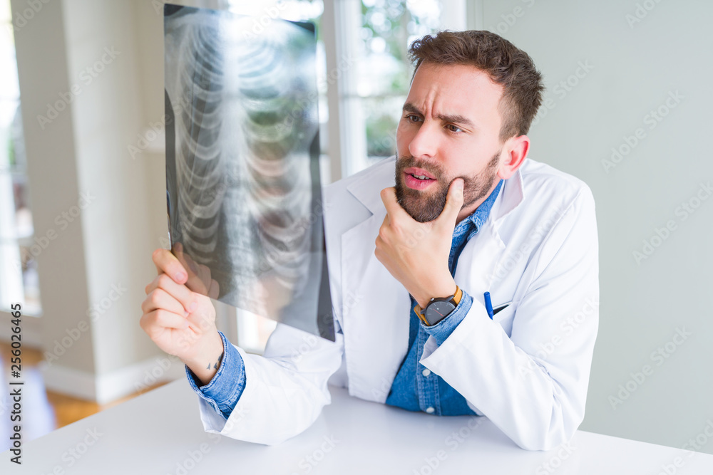 Fototapeta premium Doctor man looking at x-ray radiography doing body examination