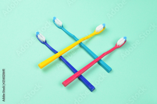 Toothbrushes on a green background. Space for text or design. © Nikolay