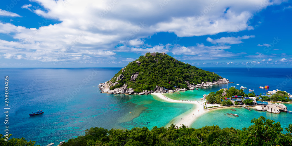 Panoramic view of green tropical island in Thailand against blue sky with clouds. 