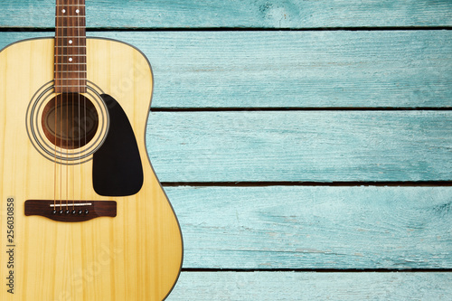 Acoustic guitar on turquoise vintage wooden wall 