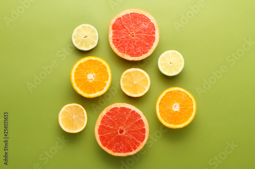 Colorful sliced fruits on green background