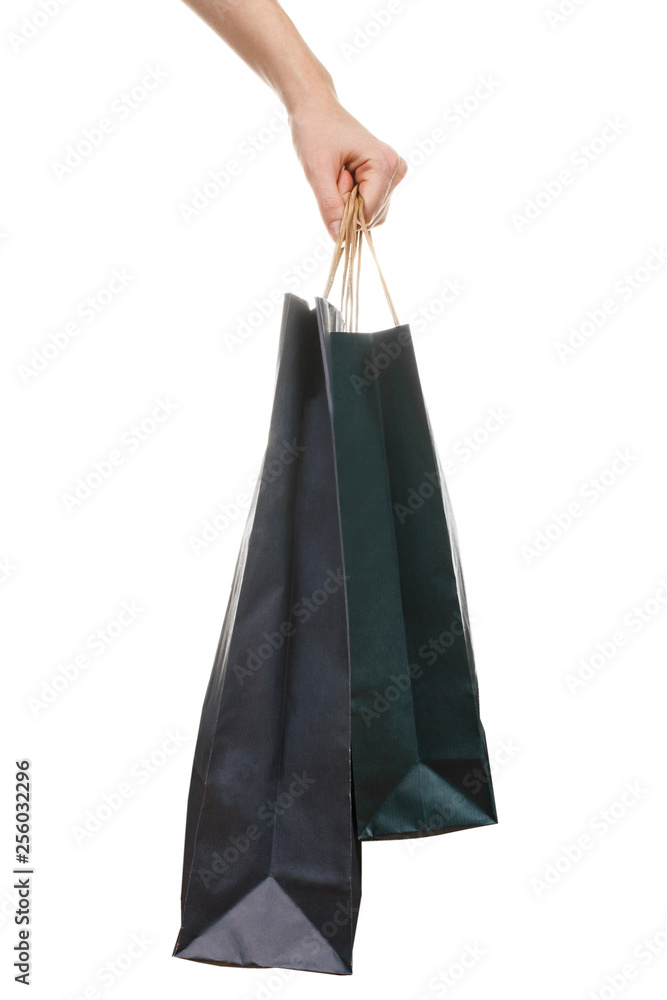Hand holding two dark paper bags isolated on white background