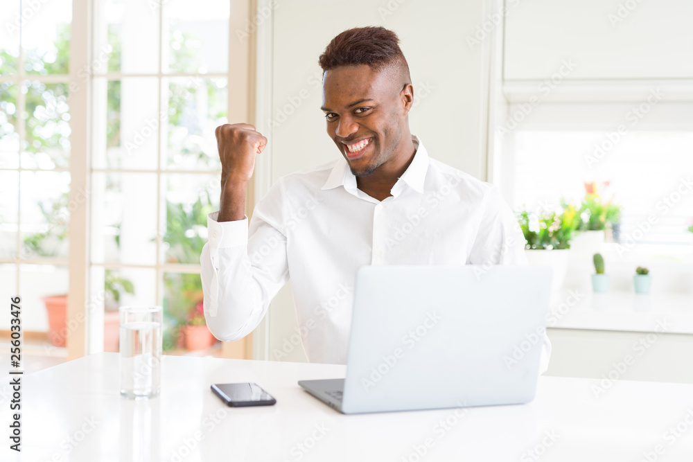 African american business man working using laptop smiling with happy face looking and pointing to the side with thumb up.