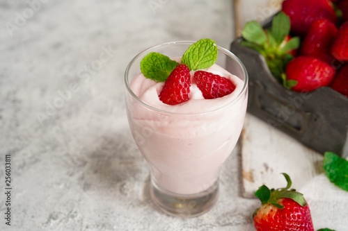 Homemade Strawberry Mousse topped with berries and mint leaf garnish, selective focus