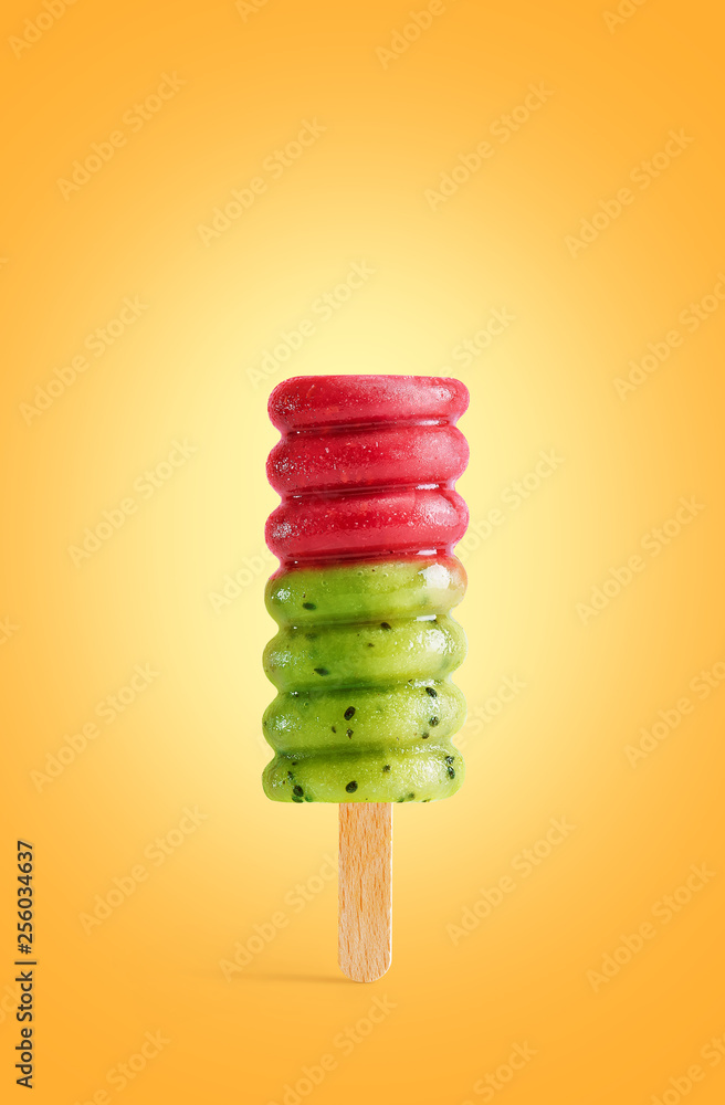Red and green fruit ice cream isolated on a yellow summer background. Colorful popsicle Red and green fruit ice cream isolated on a yellow summer background. Colorful popsicle