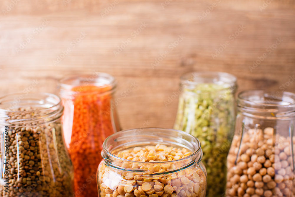 Assortment of dry organic beans and lentils in glass jars . Variety of raw legumes. Assortment of dry organic beans and lentils in glass jars . Variety of raw legumes.