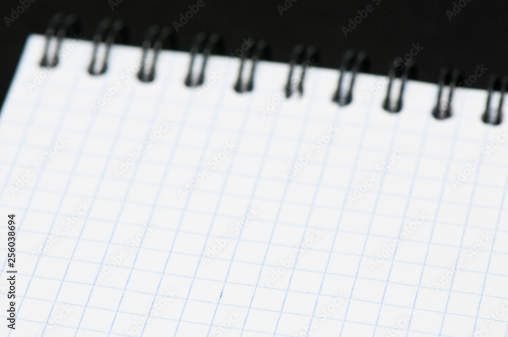 Blank sheet of a notebook (squared), on black background Blank sheet of a notebook (squared), on black background