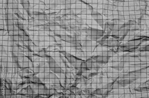 One crumpled grey blank paper sheet of a notebook  in grid  background 