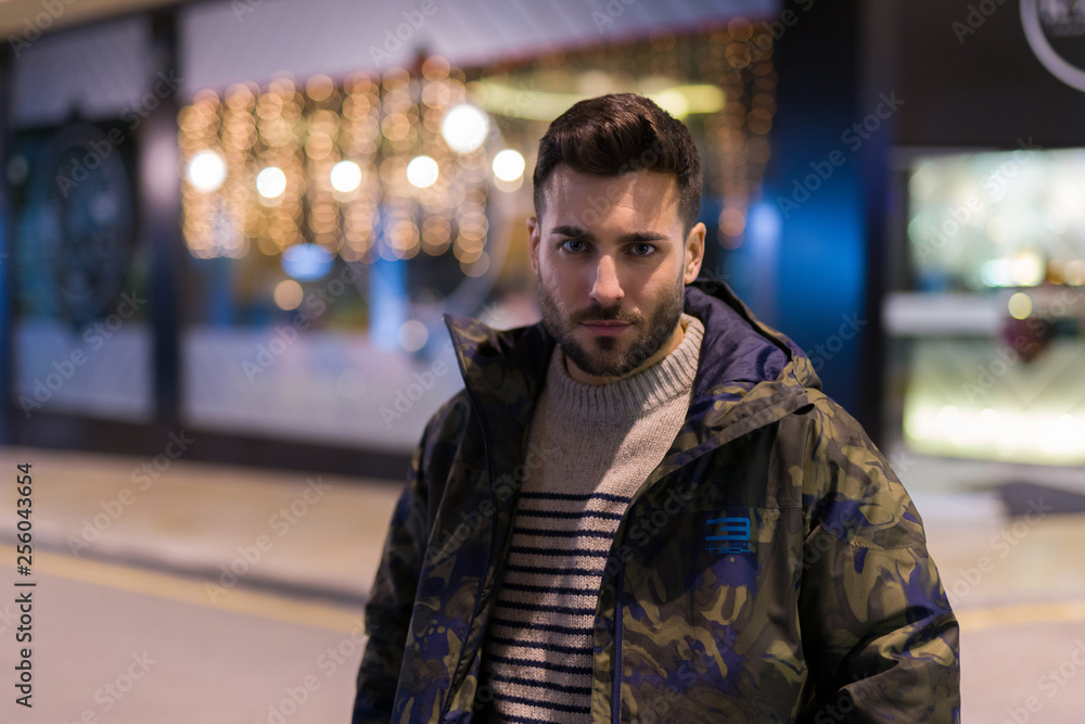 Young handsome man possing and smiling. Street style at night Young handsome man possing and smiling. Street style at night