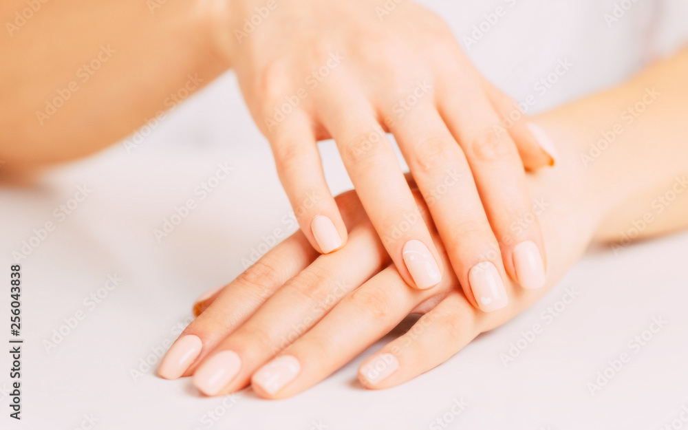 Female hands with beige manicure.