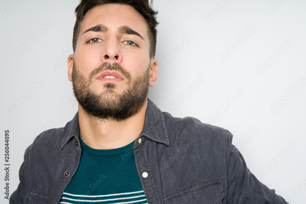 Fototapeta premium Young handsome man possing and modeling over grey isolated background