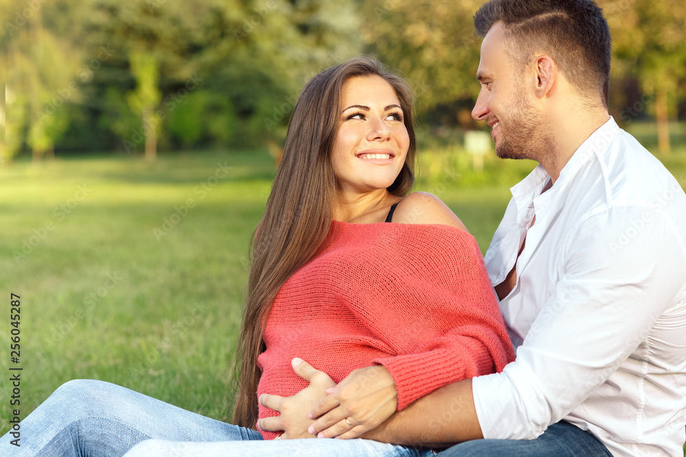 Her biggest support. Portrait of a young pregnant couple relaxing on the grass together looking at each other with love Her biggest support. Portrait of a young pregnant couple relaxing on the grass together looking at each other with love