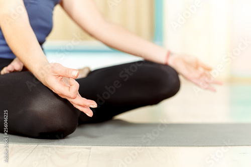 Details matter. Cropped close up shot of a woman mediating with her hands on her knees