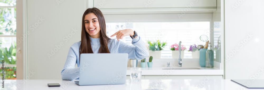 Wide angle picture of beautiful young woman working or studying using laptop with surprise face pointing finger to himself Wide angle picture of beautiful young woman working or studying using laptop with surprise face pointing finger to himself