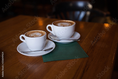 Two cups of cappuccino on a wooden table