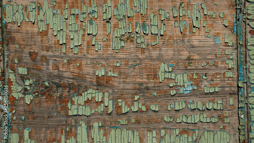 Photo of a wooden surface with old green paint. Close up. A retro a background with a wooden blank and painting. Beautiful texture for registration of design.