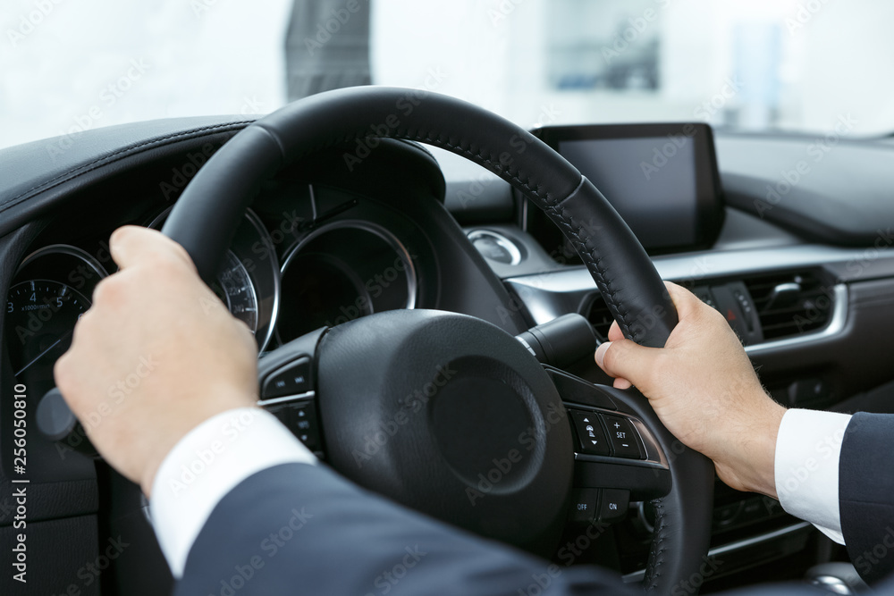 Perfect feeling. Close up shot of businessman holding the steering wheel with his hands