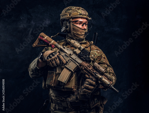 Canvas Print The elite unit, special forces soldier in camouflage uniform holding an assault rifle with a laser sight
