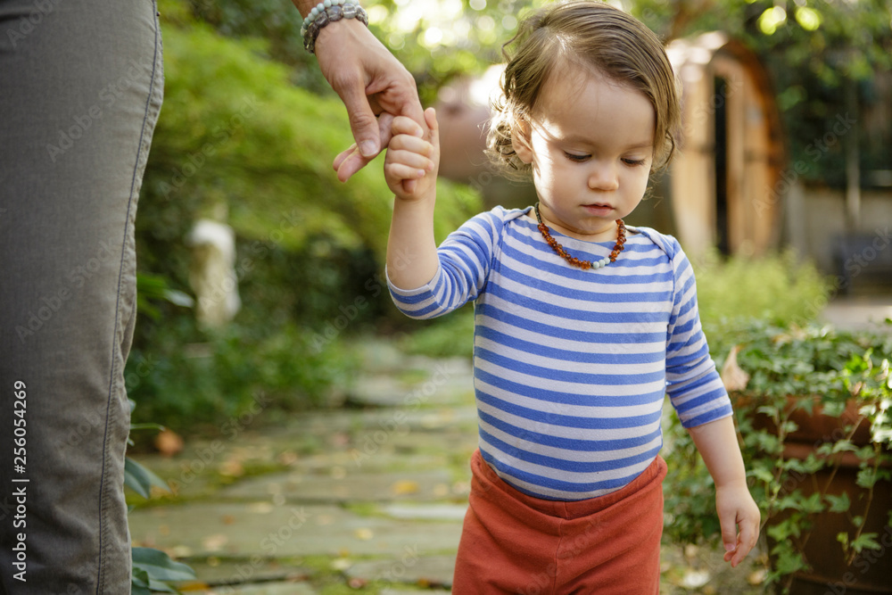 Toddler walks while holding mother's fingers Toddler walks while holding mother's fingers