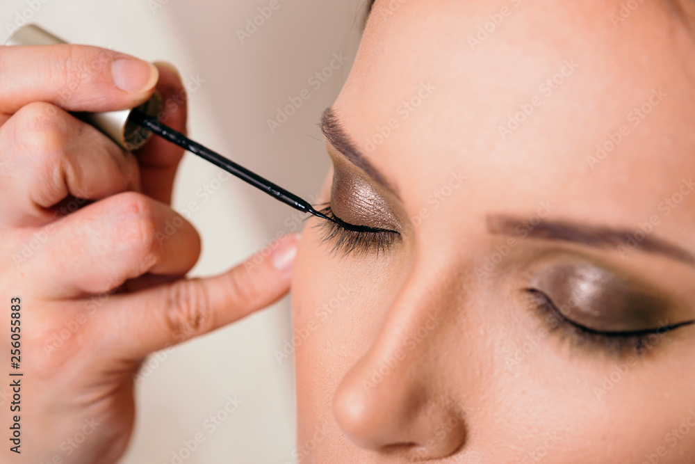 Applying eyeliner on eyelids